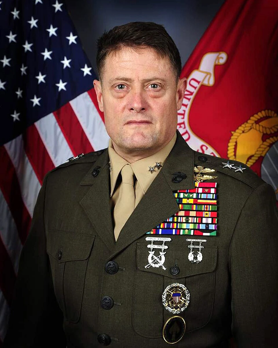 Portrait of Mark A. Clark in military uniform in front of U.S. and Marine Corps flags
