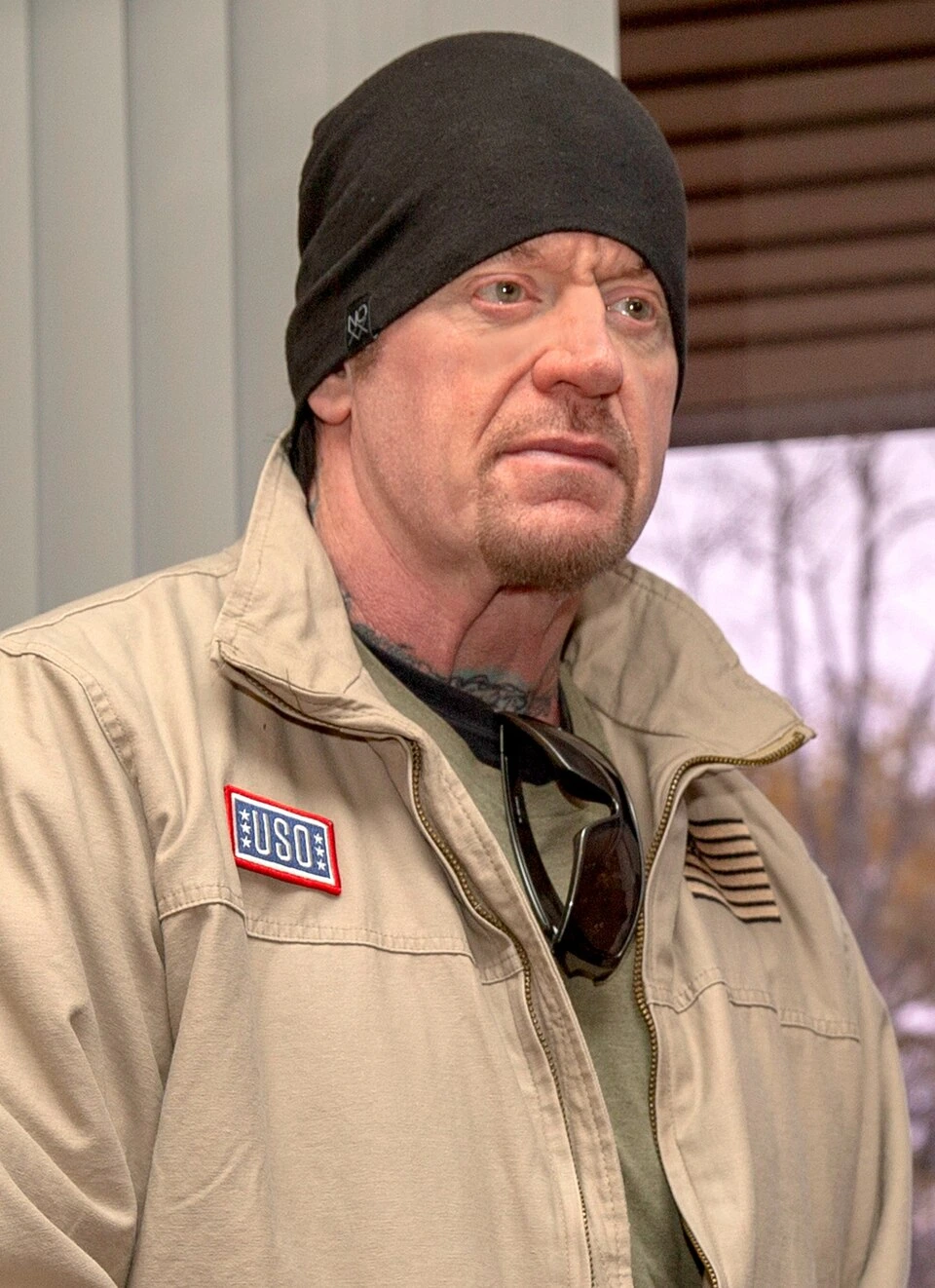 The Undertaker (Mark William Calaway) in a beanie and tan jacket during a USO visit