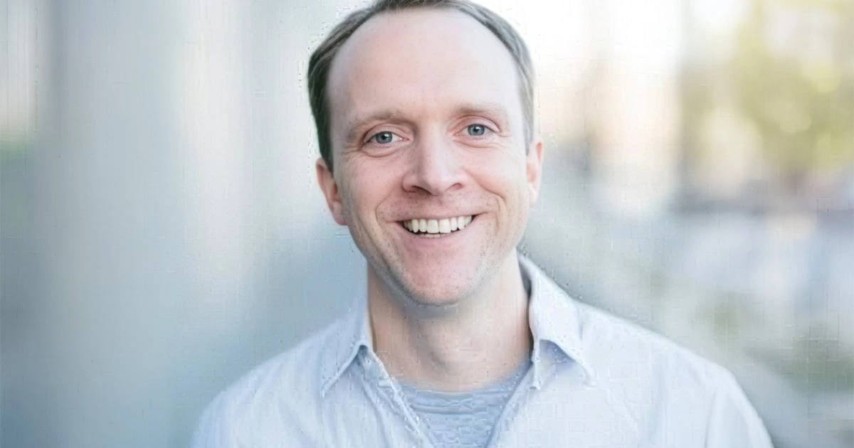 Headshot of Mark Gilbert, co-founder and CEO of Zocks, smiling against a softly blurred background.