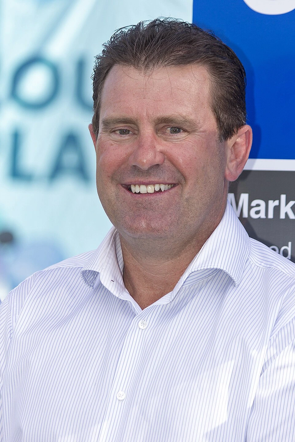Portrait photo of Mark Taylor smiling in a white shirt